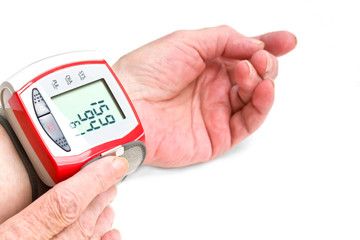 Old woman's hands measuring blood pressure