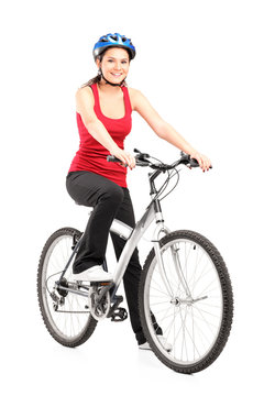 Female biker with helmet posing next to a bike
