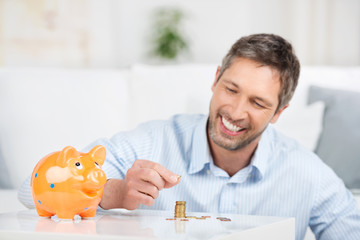 lächelnder mann stapelt münzen