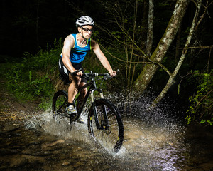 Mountainbiker durchquert Bachbett