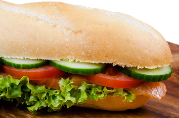 Sandwich with salmon on wooden plate