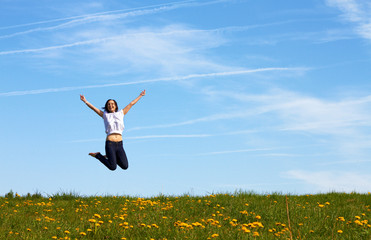 happy smiling girl jumping against blue sky