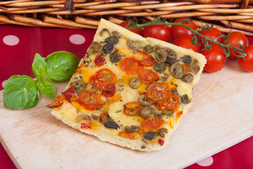Typical italian focaccia bread with cherry tomatoes and capers