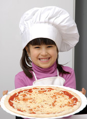 Niña chef sujetando una pizza,cocinando pizza.