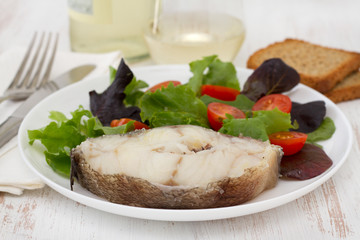 boiled fish with salad in white plate