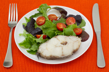 boiled fish with salad in white plate
