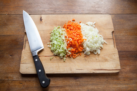 soffritto di sedano, carota e cipolla sul tagliere con coltello