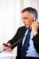 Hispanic senior business man calling on telephone