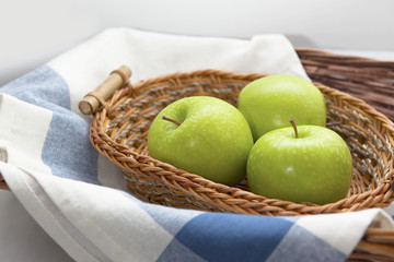 Green apples in the brown wicker basket