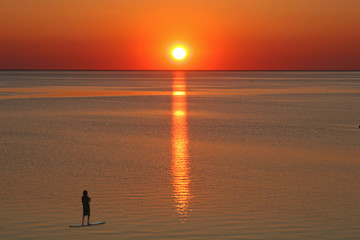 paddle boarder at sunset