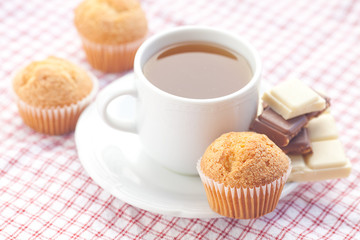 bar of chocolate,tea and muffin on plaid fabric