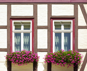 Fototapeta na wymiar Fachwerkfassade mit Fenstern und Blumenkästen