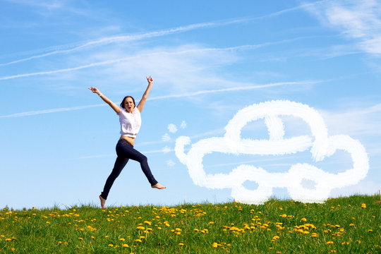 happy jumping girl with drawn car against blue sky