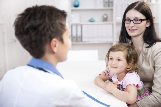 Pediatrician talking to mother and child at office