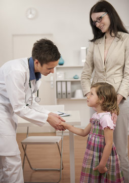 Pediatrician shaking hand with girl child patient