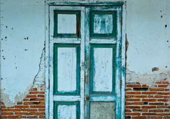 Old wooden door on cracked brick wall