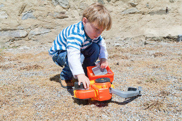 little boy playing with plastic toy