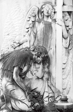 cemetery relief with angel and cross and crying woman figure wit