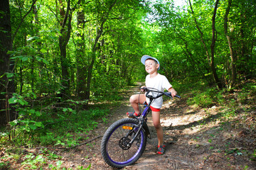 Fototapeta premium Portrait of a cute boy on bicycle
