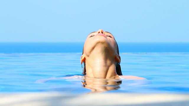 Lovely girl spending time in exotic swimming pool