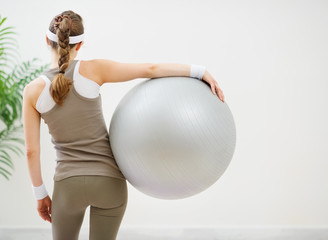 Fototapeta premium Athletic woman with fitness ball standing back to camera