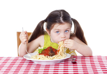 Beautiful girl eating pasta and meatballs with hands