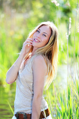 Beautiful blond woman standing in meadow with modern look