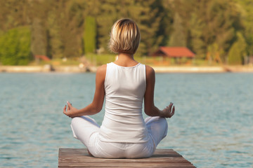 Fototapeta na wymiar Young woman yoga on the lake