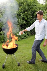 Mann mit Feuer beim Grillen