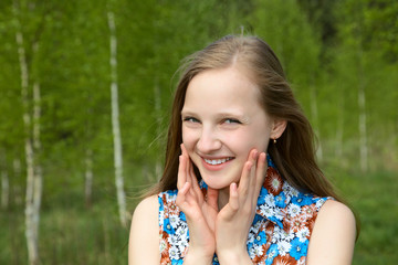 girl with a smile against young birches