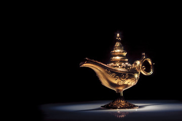 Magic Aladdin's Genie lamp on black - obrazy, fototapety, plakaty