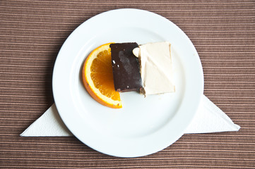 Top view Chocolate and vanilla cake  with slice of orance