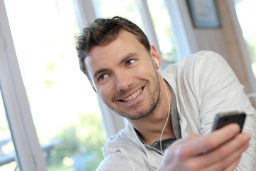 Young man using mobile phone with handsfree headset