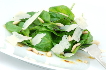 Fresh green spinach leaves salad close up white background.