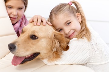 Little girl hugging pet dog smiling