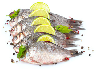 Fresh fishes with lime, parsley and spice isolated on white