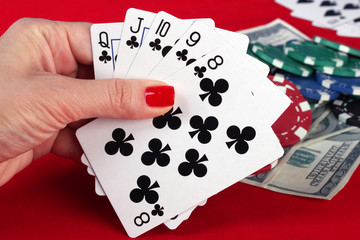 Woman's hand holding playing cards straight flush