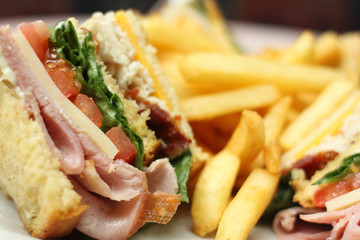 Delicious club sandwich with french fries.