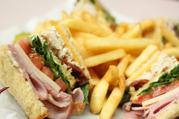 Delicious club sandwich with french fries.