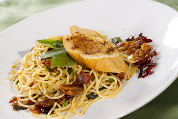 saute pasta with dried chili and piece of bread on top