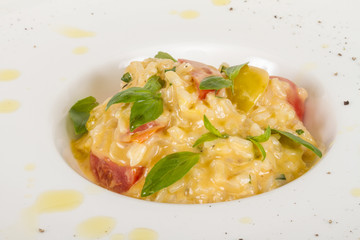 photo of delicious risotto dish with herbs and tomato on white b