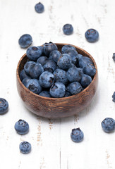 bowl with fresh blueberries on wooden table