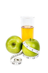 Green apples with measurement tape with glass of apple juice