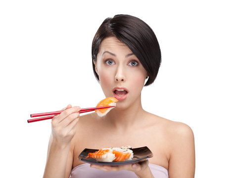 Surprised young woman holding sushi with a chopsticks