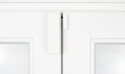 Fotobehang Wireless alarm sensor for window and door on white wooden sash © stevanzz