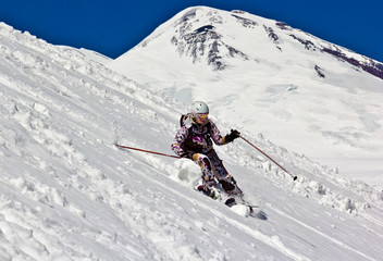 Woman skier in the soft snow on the mountain backdrop