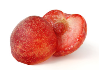 Red pluot cut in half, isolated on white background