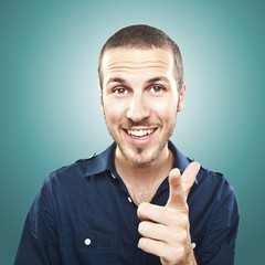 Portrait of happy young manpointing at you