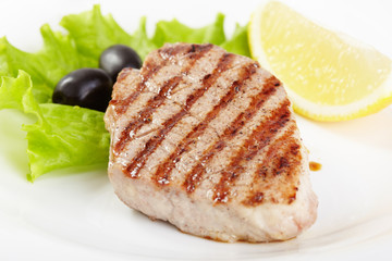 Grilled steak on white plate closeup