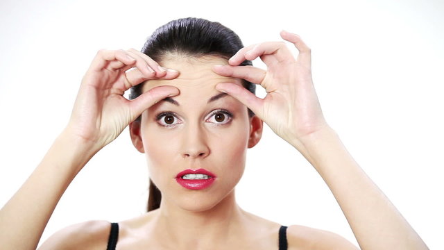 Woman checking her wrinkles on her forehead